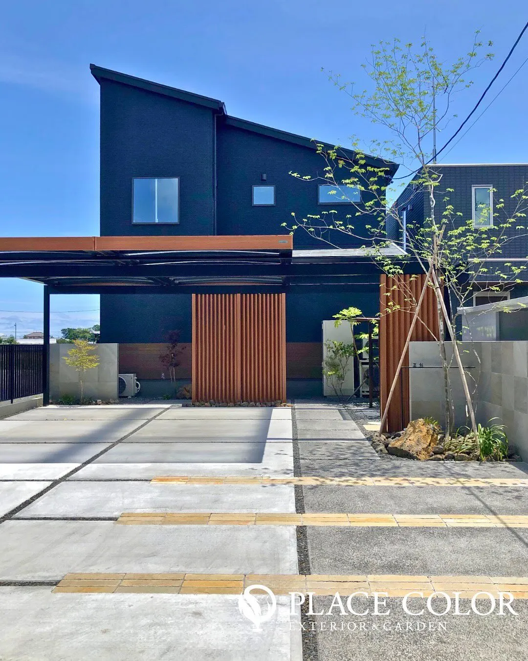 木調の格子や門柱が黒い外壁と美しく調和し、洗練された印象のフ...