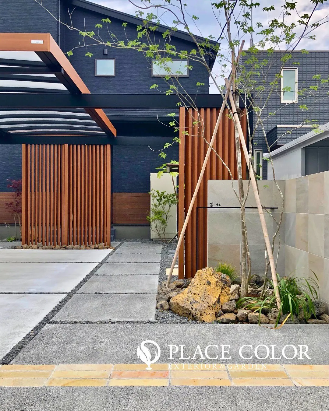 木調の格子や門柱が黒い外壁と美しく調和し、洗練された印象のフ...