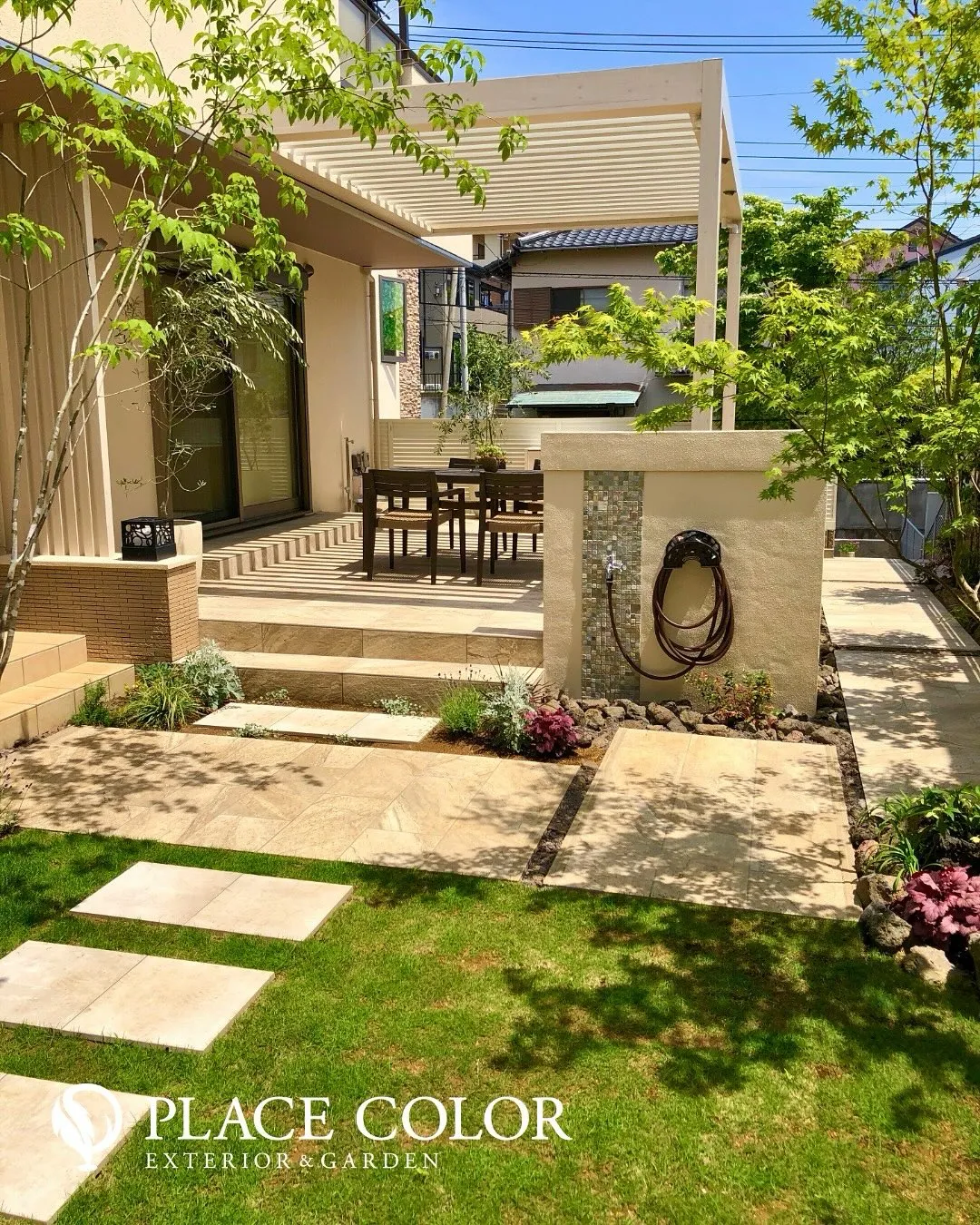 ナチュラルな石調のアプローチと緑豊かな植栽が調和し、落ち着き...