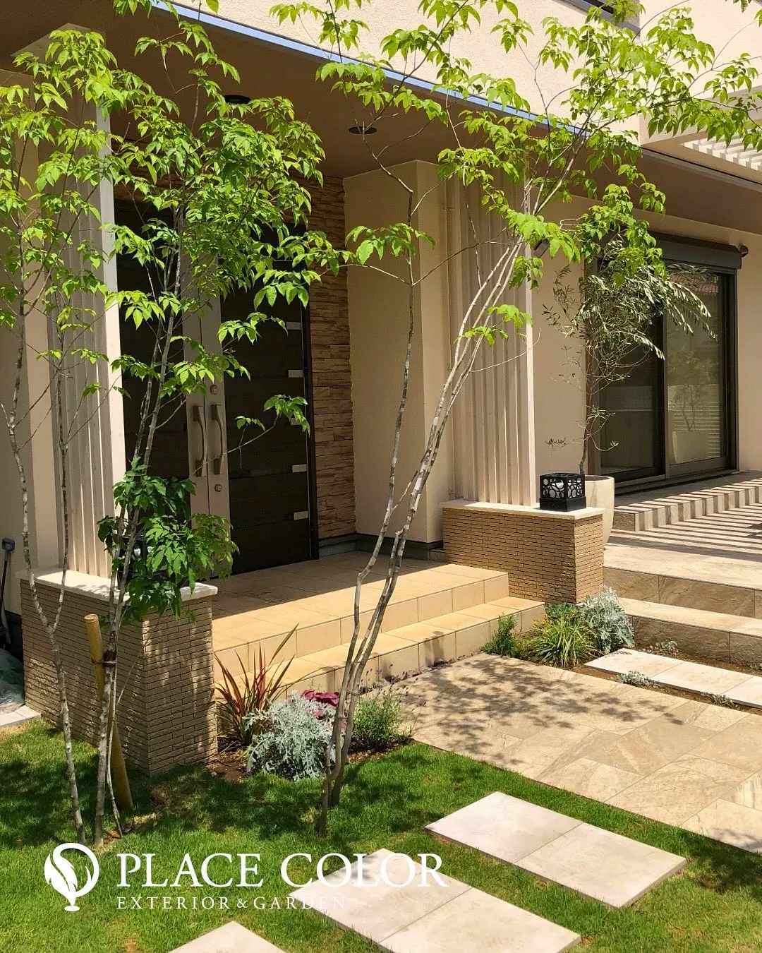 ナチュラルな石調のアプローチと緑豊かな植栽が調和し、落ち着き...