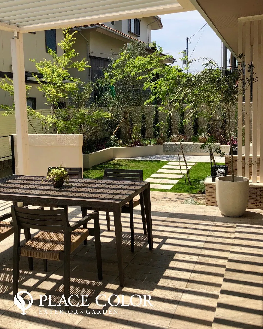 光を調整できるルーバー屋根の下に、アウトドアリビングを設けた...