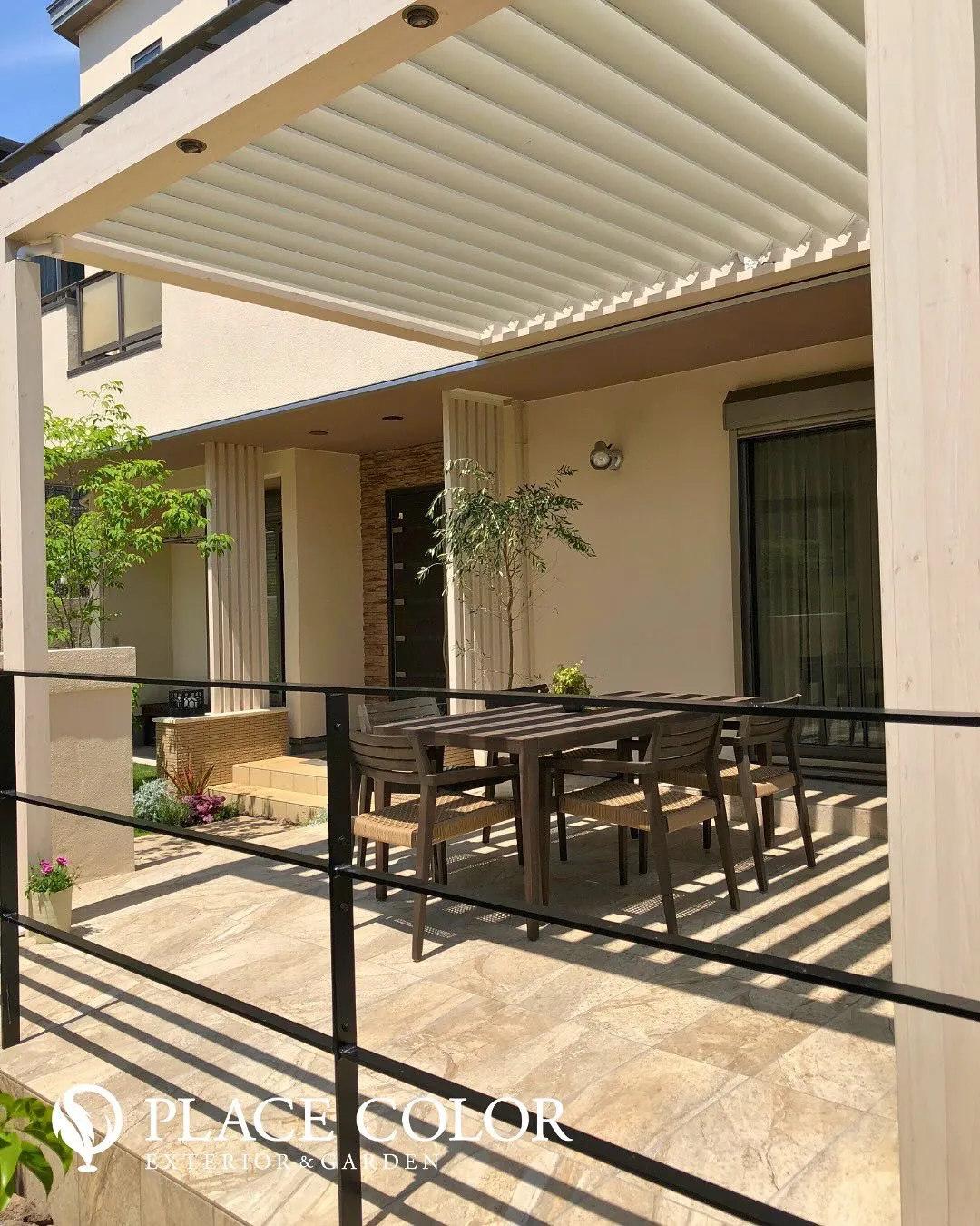 光を調整できるルーバー屋根の下に、アウトドアリビングを設けた...