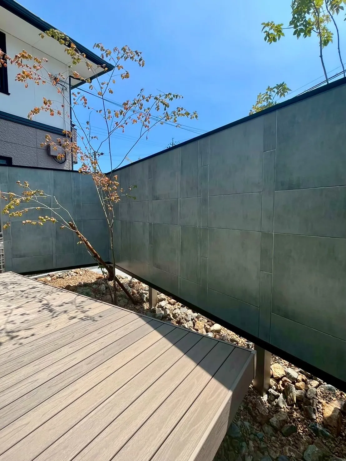 ウッドデッキと植栽を囲む、プライベート感のある落ち着いた庭空間