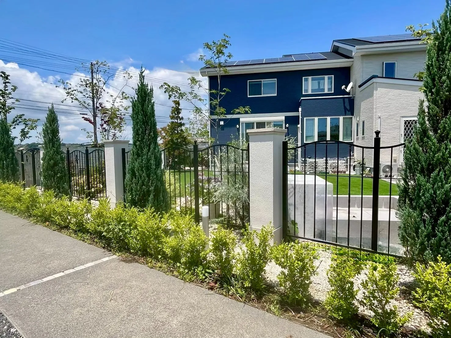 アイアン門扉と植栽が調和した、ヨーロッパ風の上品な外構デザイン