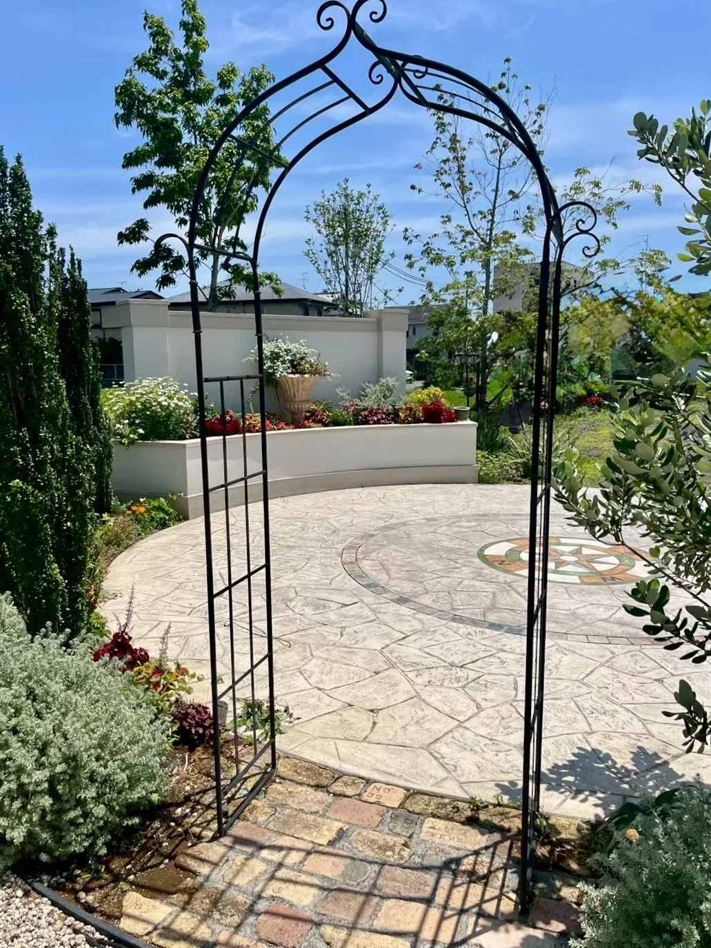 アイアンアーチと花壇が彩る、華やかで迎え入れるようなガーデンアプローチ