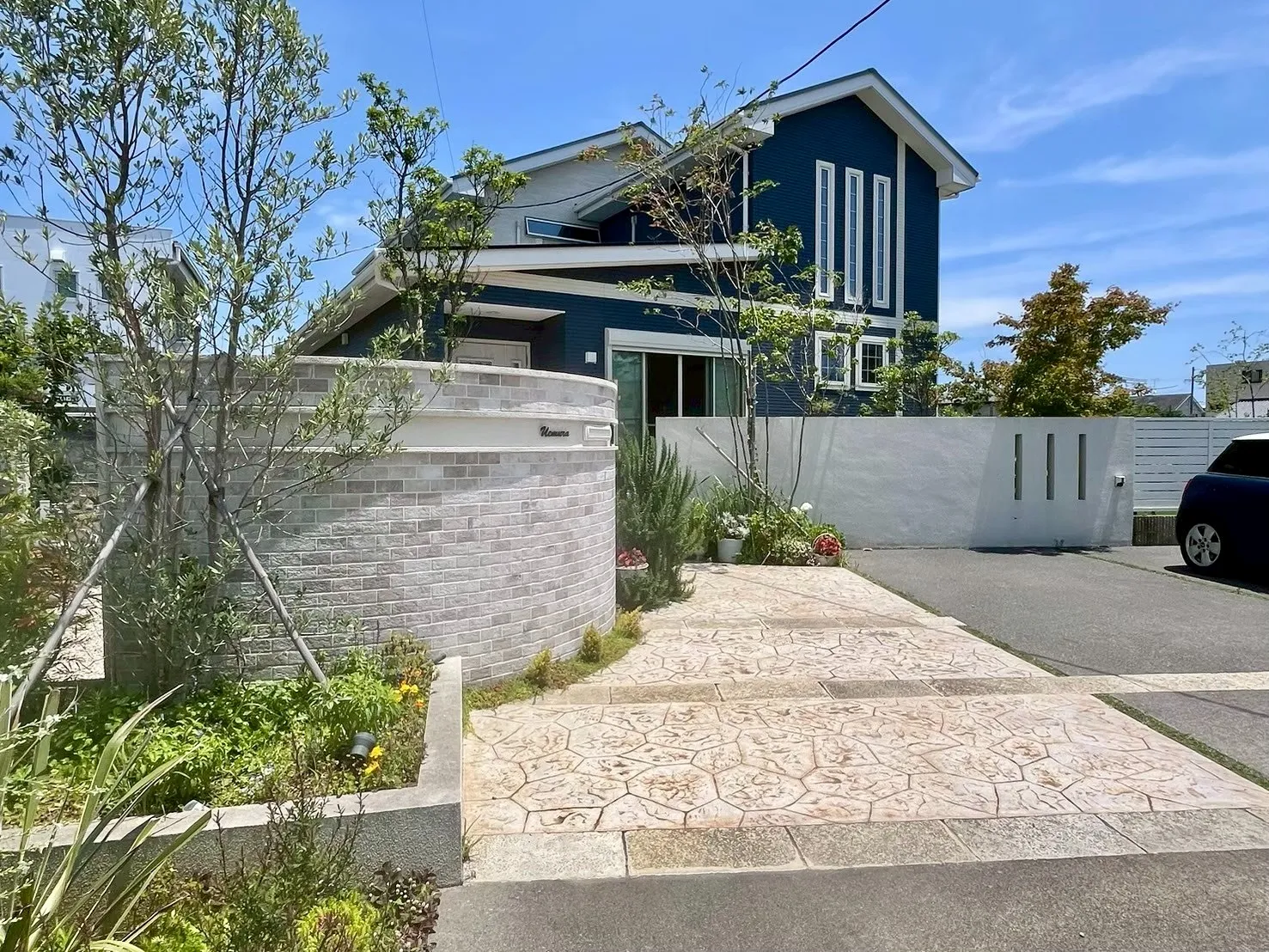 曲線の門柱と植栽が調和した、ナチュラルで柔らかい印象の外構デザイン