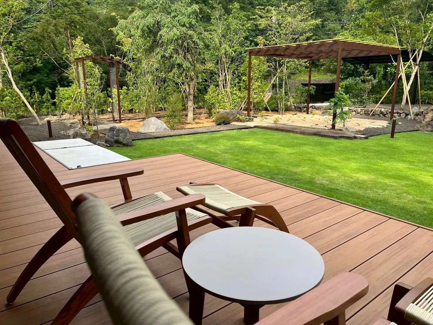 ウッドデッキから芝庭とパーゴラを望む、開放感あふれる癒しのガーデン空間