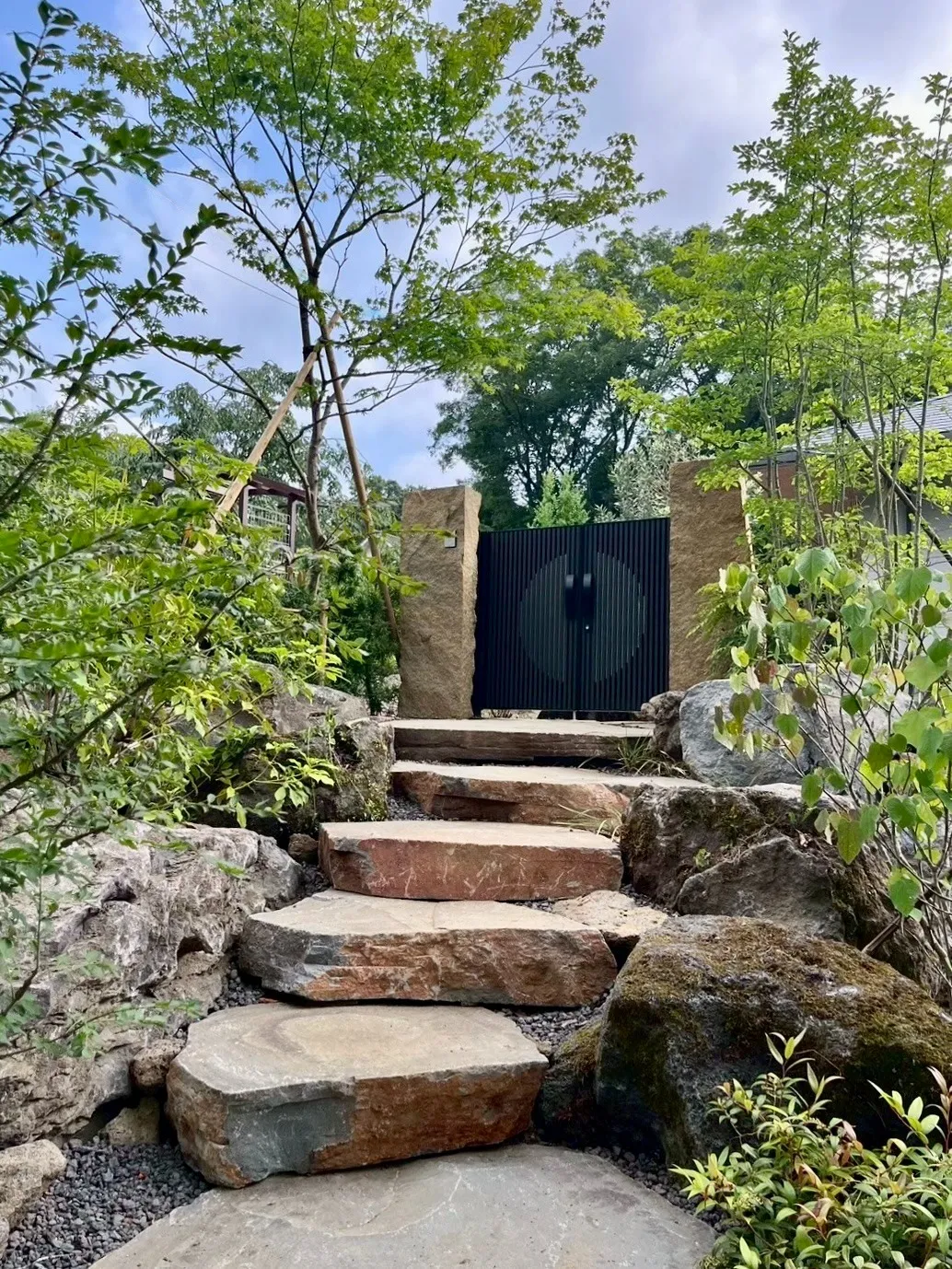 大きな自然石の階段と緑が調和する、重厚で趣深いアプローチ
