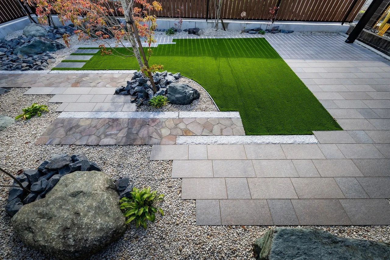 タイルやアプローチは直線的にまとめつつ、 植栽まわりや芝生の縁に緩やかな曲線を取り入れ、硬さを和らげています。