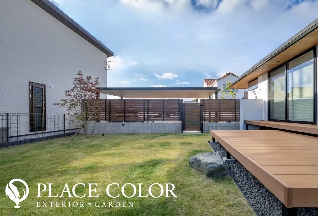 広々とした芝生と建物に沿って設けたウッドデッキが、内と外をゆ...