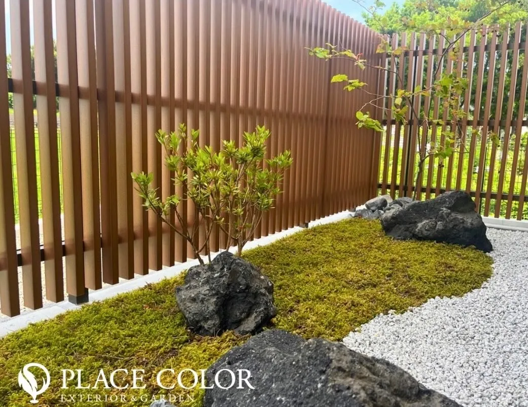 苔の緑と白砂利、自然石のコントラストが美しく、小さな植栽が季...